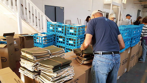JFCS volunteers prepare file boxes for distribution. The donated cartons are designed to easily store and transport paperwork, recovery claims, and receipts after a natural disaster.