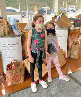 Alanna Klein’s daughters, Marlo Robin, age 6, and Sadie Robin, age 9, are among the many Brandeis students donating food to the JFCS High Holiday Food Drive.