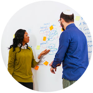 people working on a white board