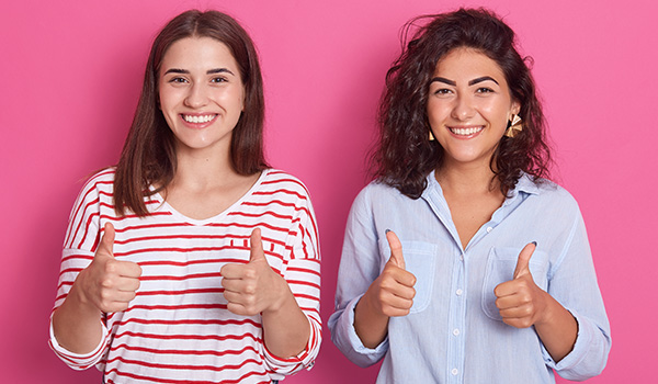 Two Young Women Giving Thumbs Up