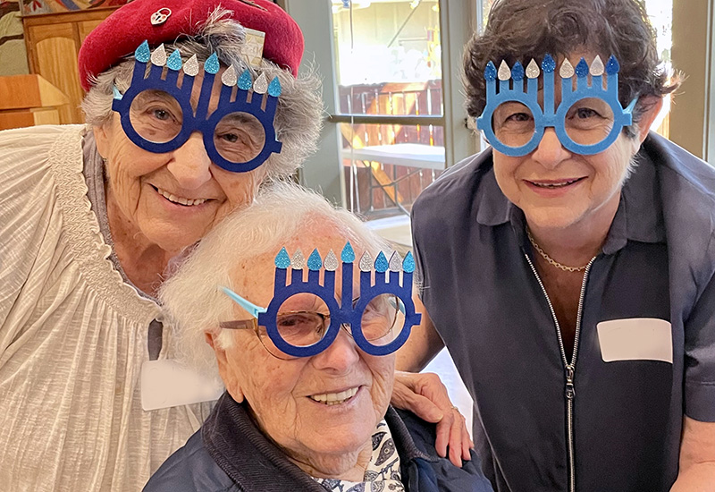 Sylvia and Luba, both Holocaust survivors, celebrate Hanukkah with Tzippi, a long-time JFCS volunteer.
