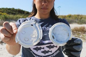 person holding up beach trash