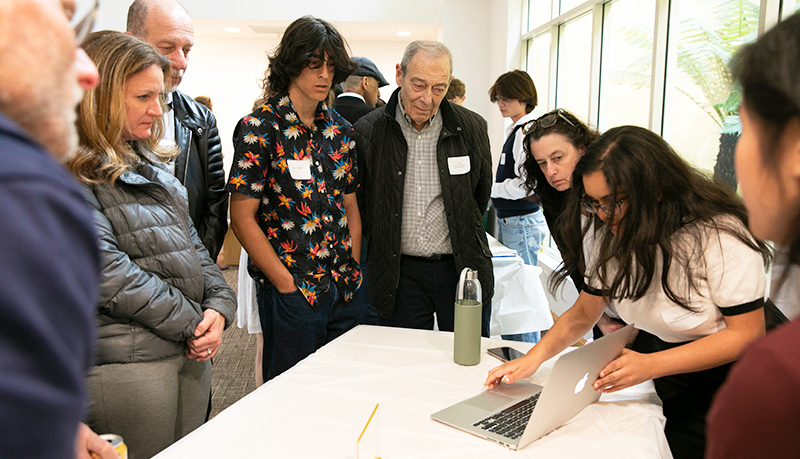 Guests at presentations observe Divisha Khanna's project 