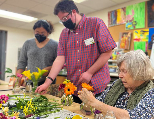 YoutFirst Participants helping seniors with flowers. 