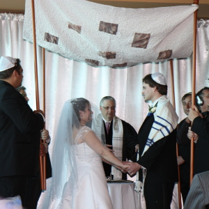 A Jewish wedding taking place under a huppah.