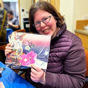 Nona, a treasured member of the Shupin Community, displays a collage she created during an art workshop
