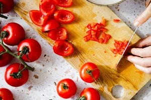 person slicing tomatoes